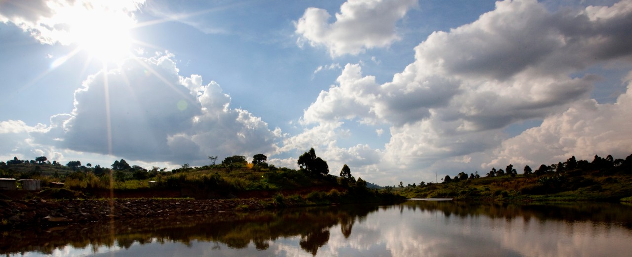 Sun and clouds reflect on a river landscape