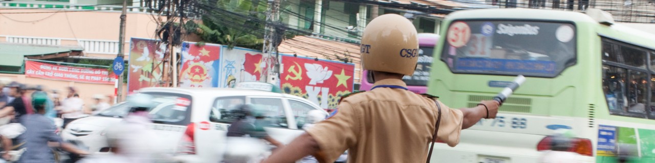 A police officer regulates traffic in an Asian city