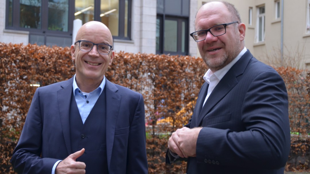 Mark Schwiete und Michael Jainzik stehen im Hof der KfW.