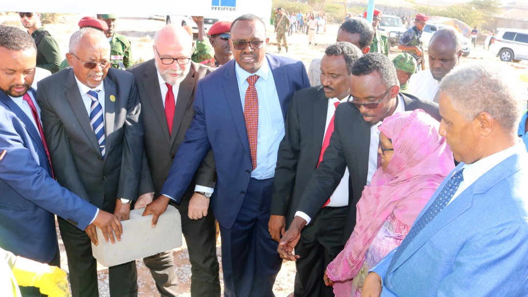 8 people, politicians and the CEO of Hargeisa Water Agency symbolically lay the foundation stone for their common programme.