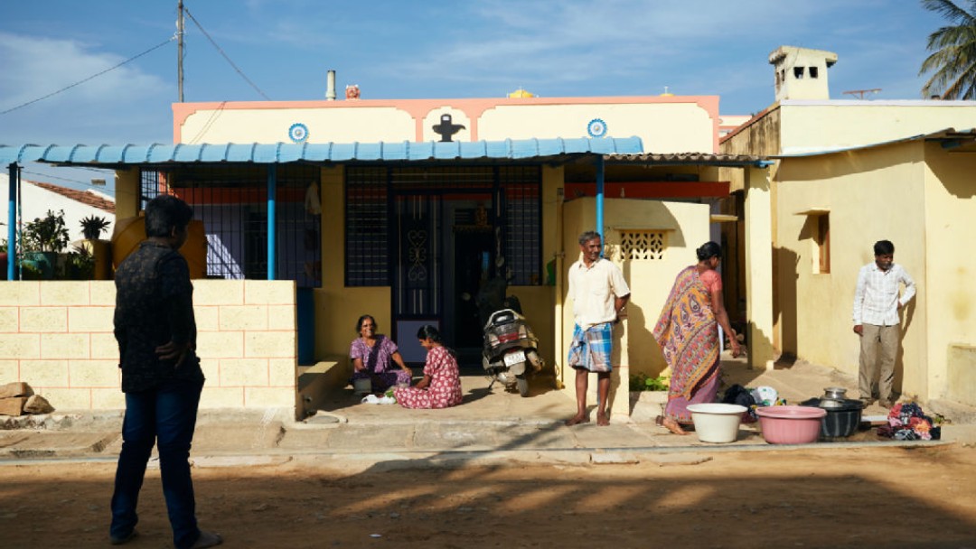 Eine indische Familie beim Kochen vor ihrem Haus in einer indischen Vorstadt. 