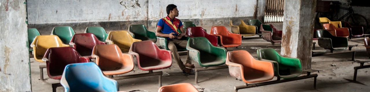 Ein Mann sitzt einzeln in einer Wartehalle