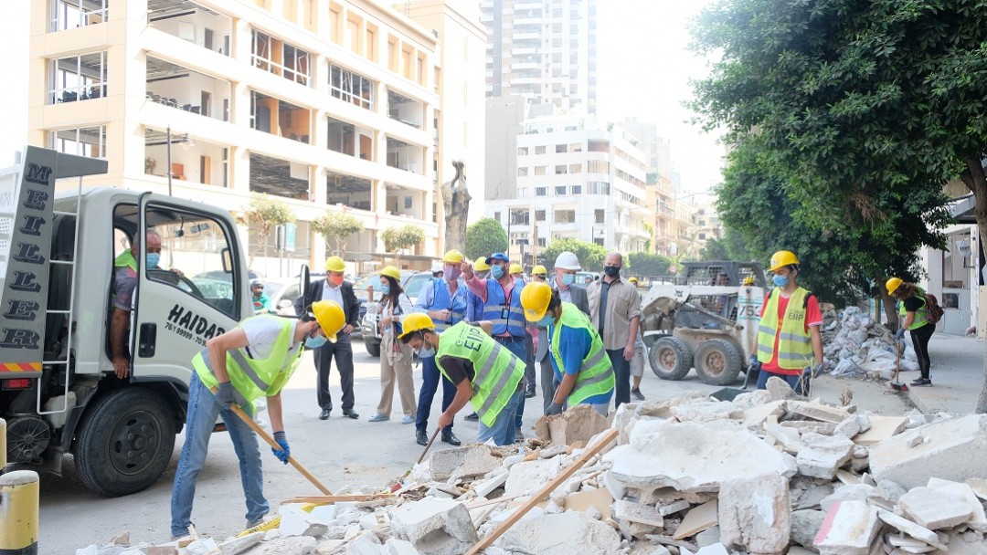 Lebanese and Syrians clear away the rubble. 