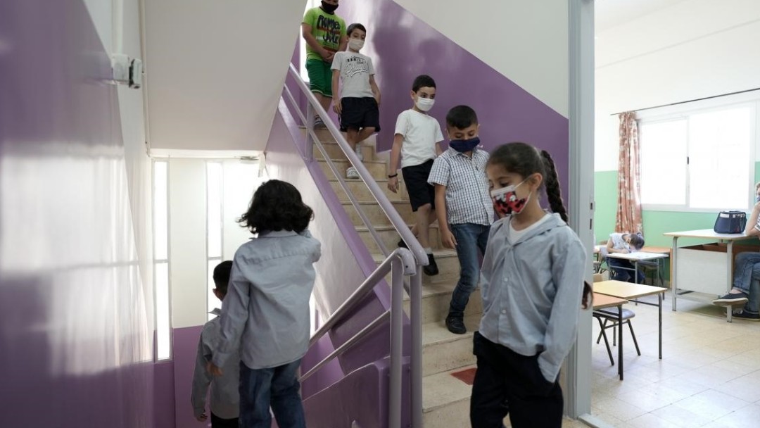 Schulkinder laufen in einem Treppenhaus nach unten