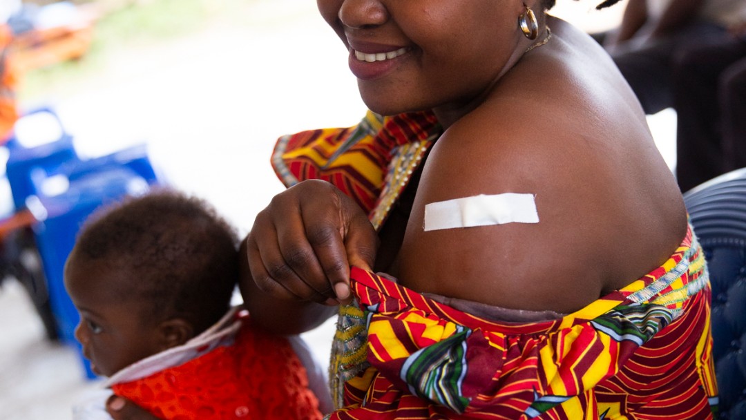 Mother with her child on lap and a bandaid on her arm.