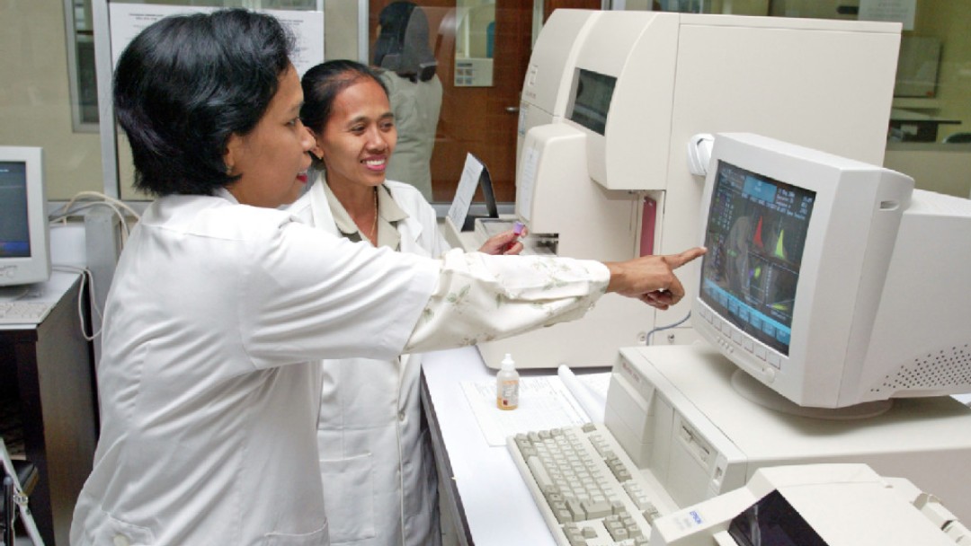 Mitarbeiterinnen eines Krankenhauses bei der Arbeit an Computern in Indonesien