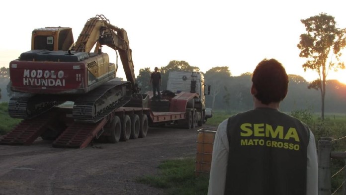 Mann schaut auf einen abgeschleppten Traktor