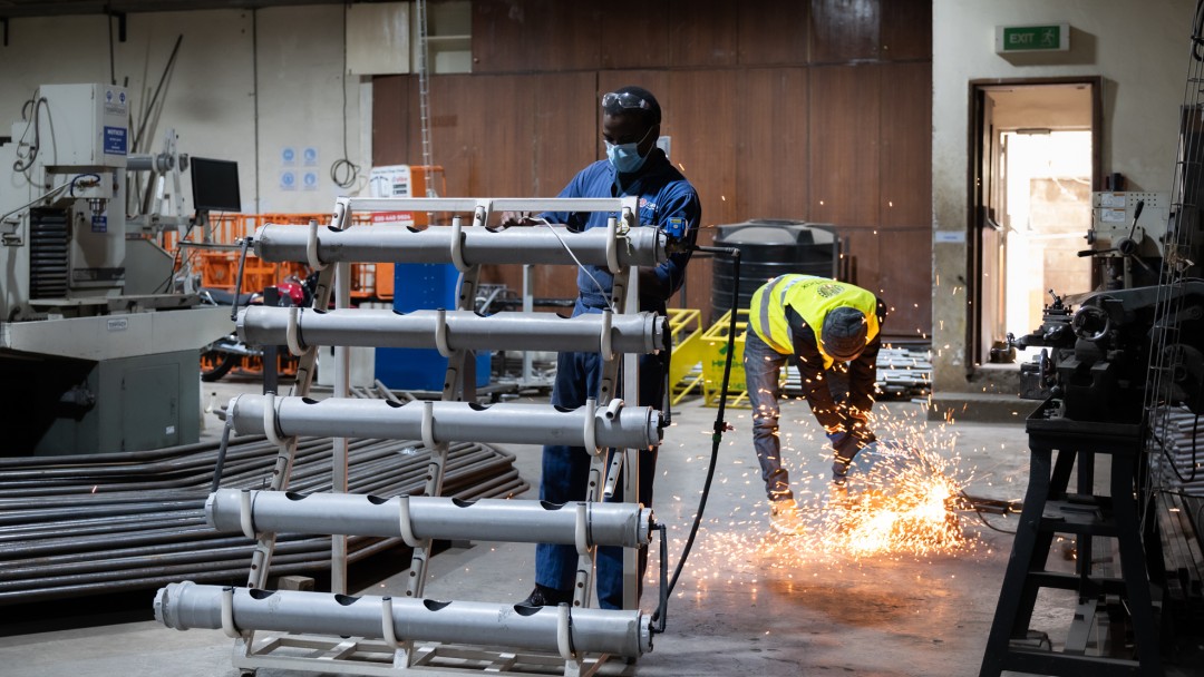 Two workers welding and finishing a greenhouse