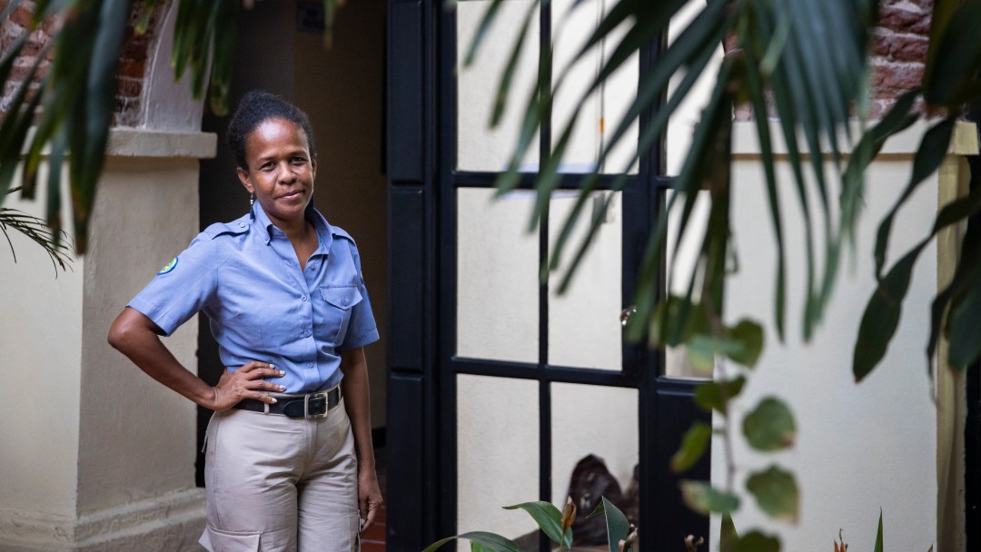 A woman with a blue shirt standing in a garden