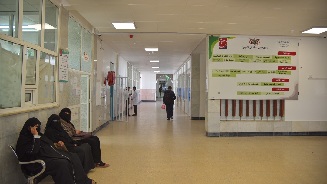 Hospital hallway with three women on a bench