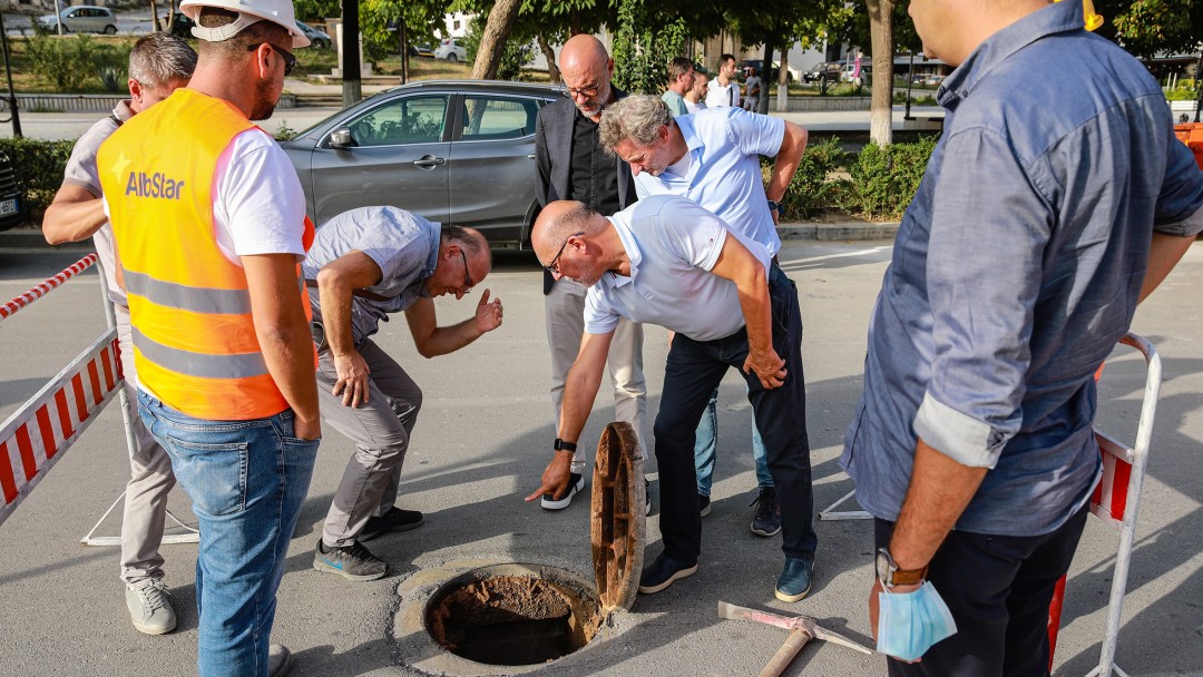 Mehrere Peronen schauen in ein Abwassersystem