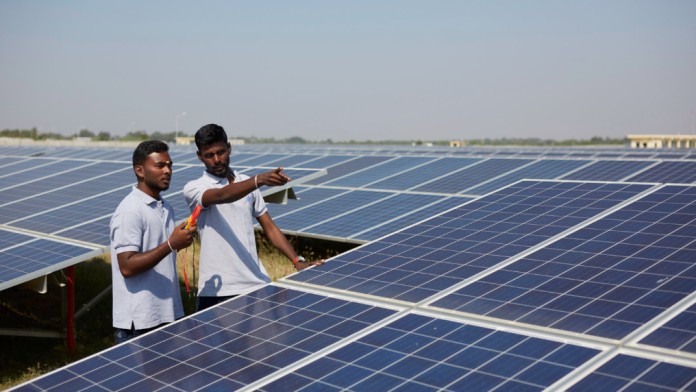Workers between solar panels