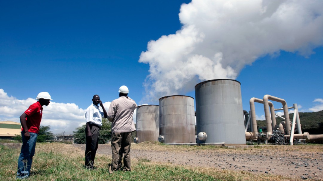 Technicians touring the outdoor facility of a geothermal heat power plant 