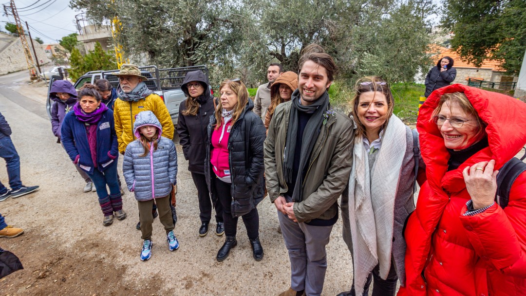 Mehrere Personen stehen nebeneinander im Regen