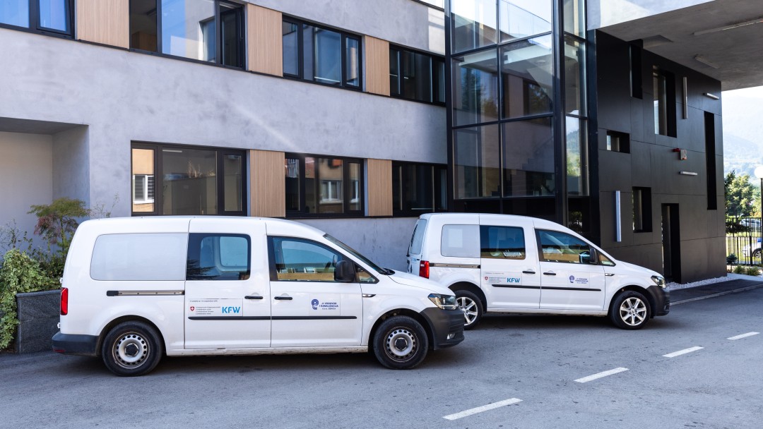 Two white vans parked in front of an office building
