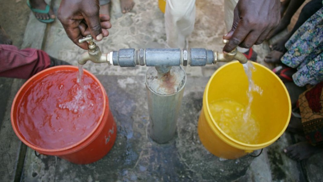 Two buckets being filled with water.