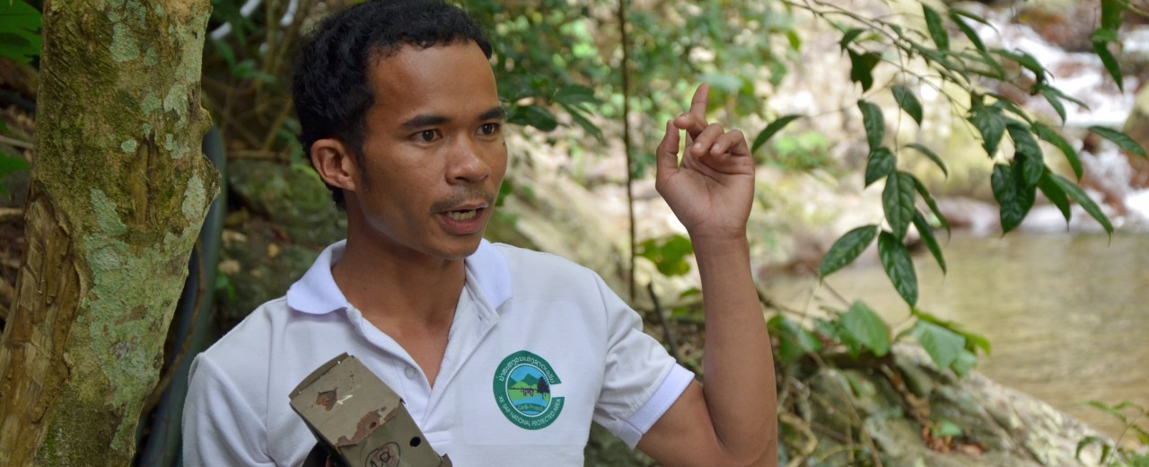 Ein junger laotischer Ranger zeigt eine Fotofalle.