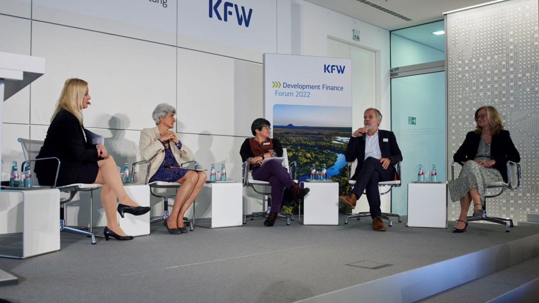 Fünf Personen diskutieren, KfW-Logo im Hintergrund