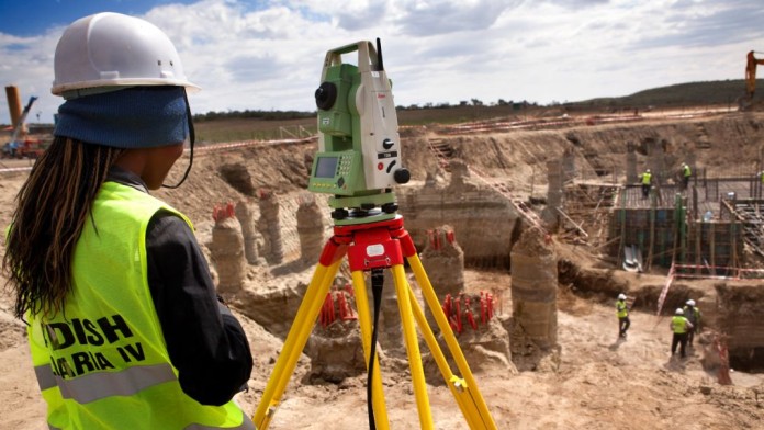 Ein Bauarbeiter vermisst die Baugrube des Fundaments für ein Geothermalwärmekraftwerk