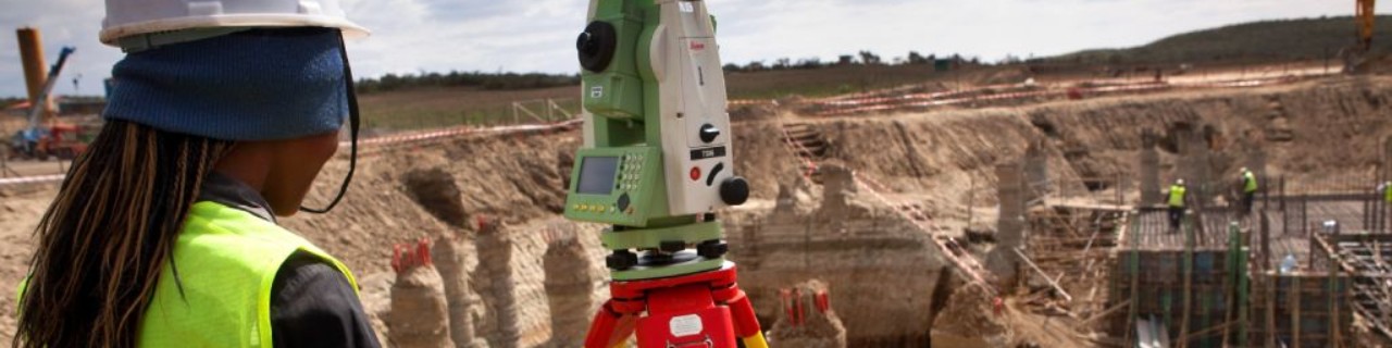 A construction worker is measuring the building site