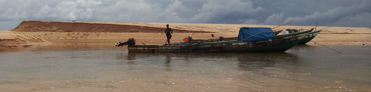 Ein Fischerboot in flachem Gewässer am Strand von Sierra Leone.