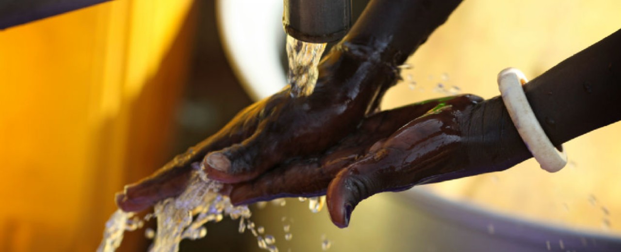 Washing hands under running water from a well