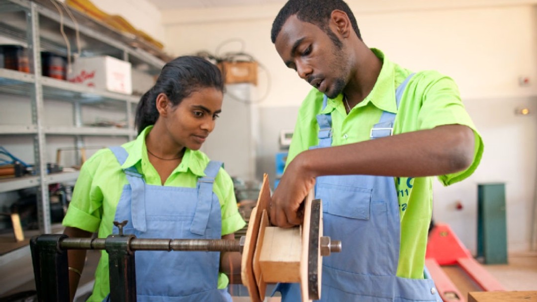 Two vocational students working on a machine 