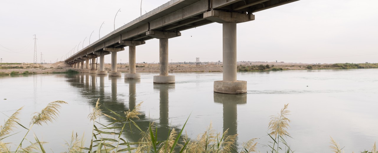 Blick vom Flussufer auf eine Brücke