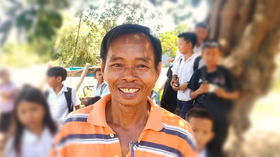 Der Direktor der Hop Primary School lacht in die Kamera