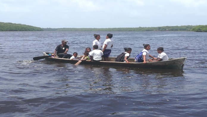 Schulkinder in einem Ruderboot