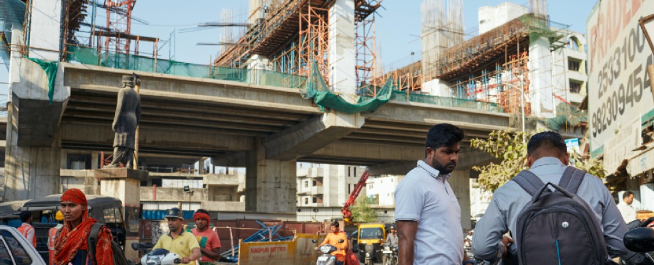 Construction of a metro, in the foreground people with mopeds.