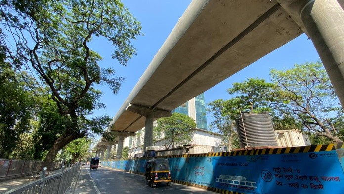 Part of the elevated metro system in Mumbai next to a road.