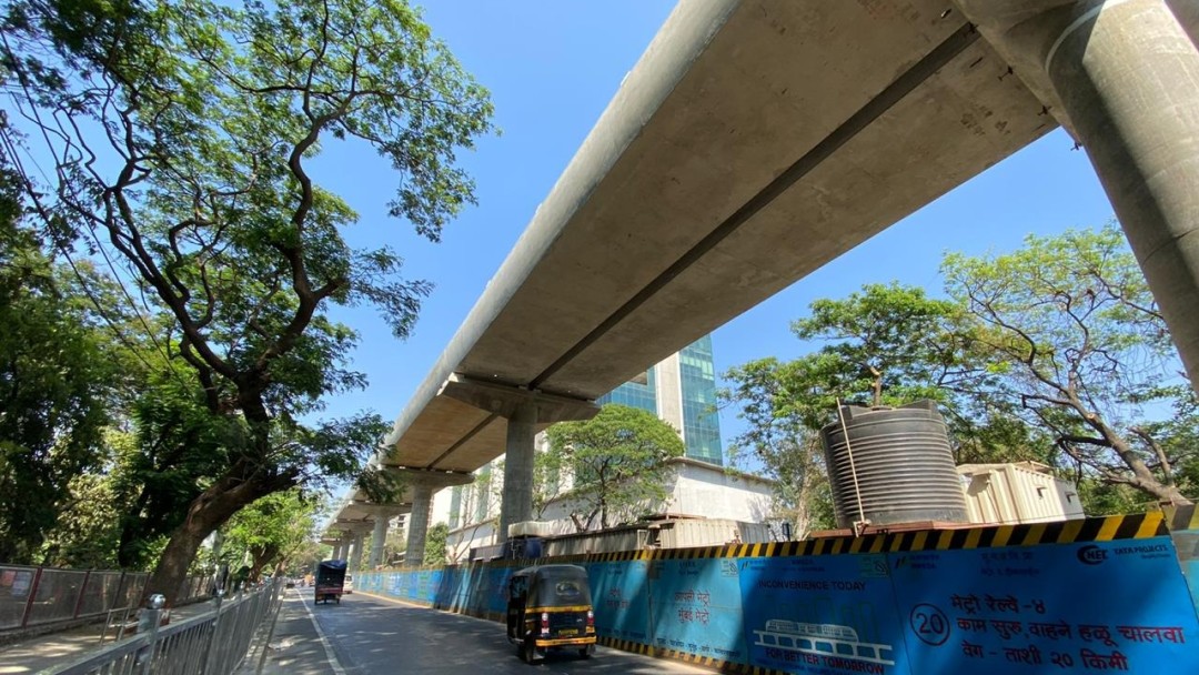 Ein Teil des hochgelagerten Metrosystems in Mumbai neben einer Straße.