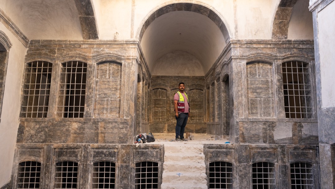 A man stands in a building in the old city of Mosul