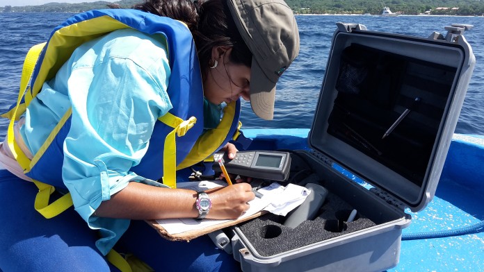 Eine Frau notiert sich Daten zur Sicherung der Wasserqualität 