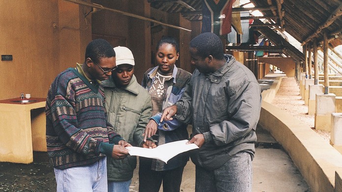 Studenten des South African Wildlife College schauen gemeinsam auf einen Plan