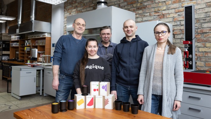 Four employees in a kitchen with their products (candles) in front of them
