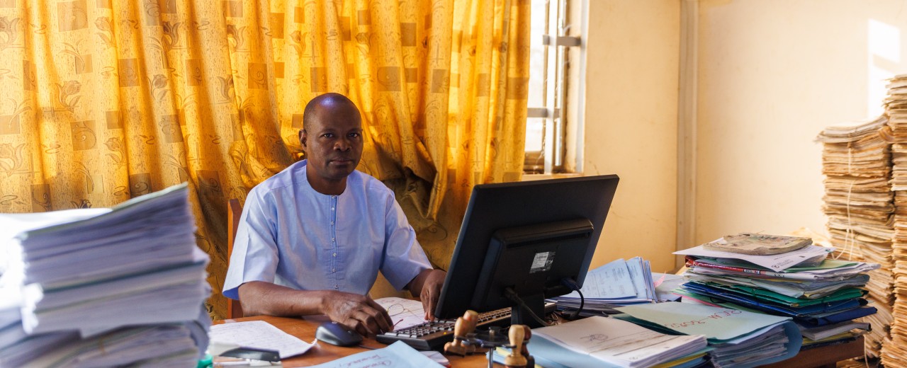 Mann sitzt am Schreibtisch und arbeitet am Computer 