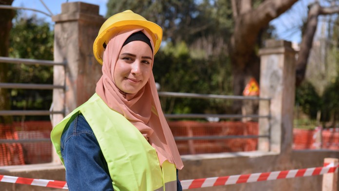 Die 21-jährige libanesische Studentin Rouya Malas mit Arbeitskleidung und -helm auf einer Baustelle