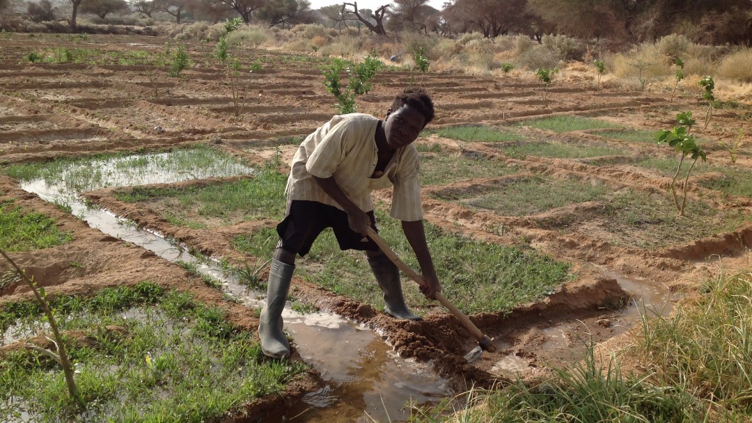 Ein Kleinbauer gräbt einen Wassergraben auf einem Feld