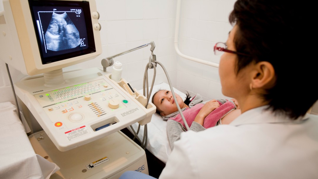 Eine Frau wird mit einem Ultraschallgerät untersucht