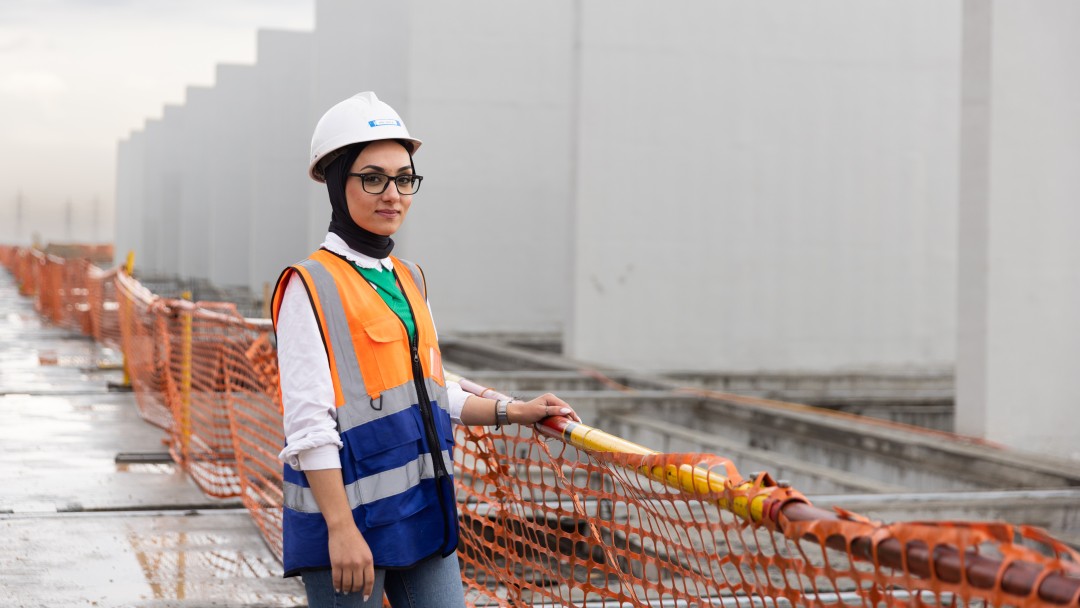 Eine Bauingenieurin steht auf einer Baustelle