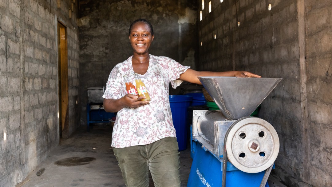 Eine Frau steht neben einer Maschine für die Produktion von Fruchtsäften