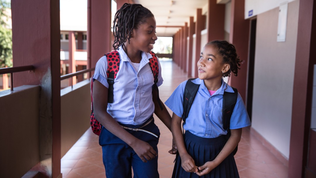 two girl talking on the floor from their school 