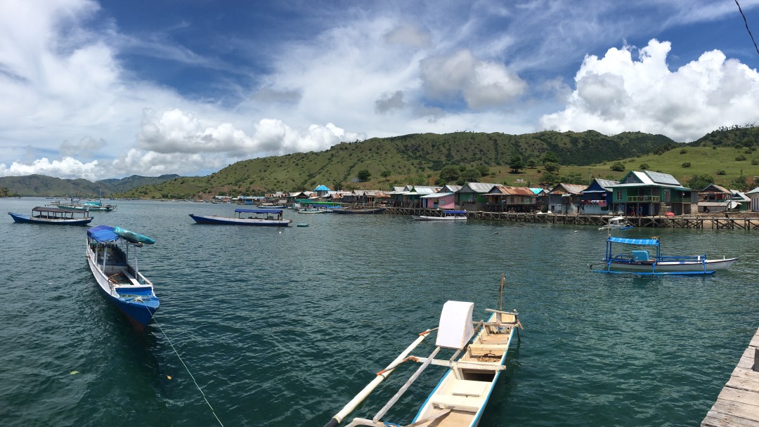 Uferprommende einer Insel in Indonesien mit Blick auf das Wasser, dort sind viele kleine Fischerboote 