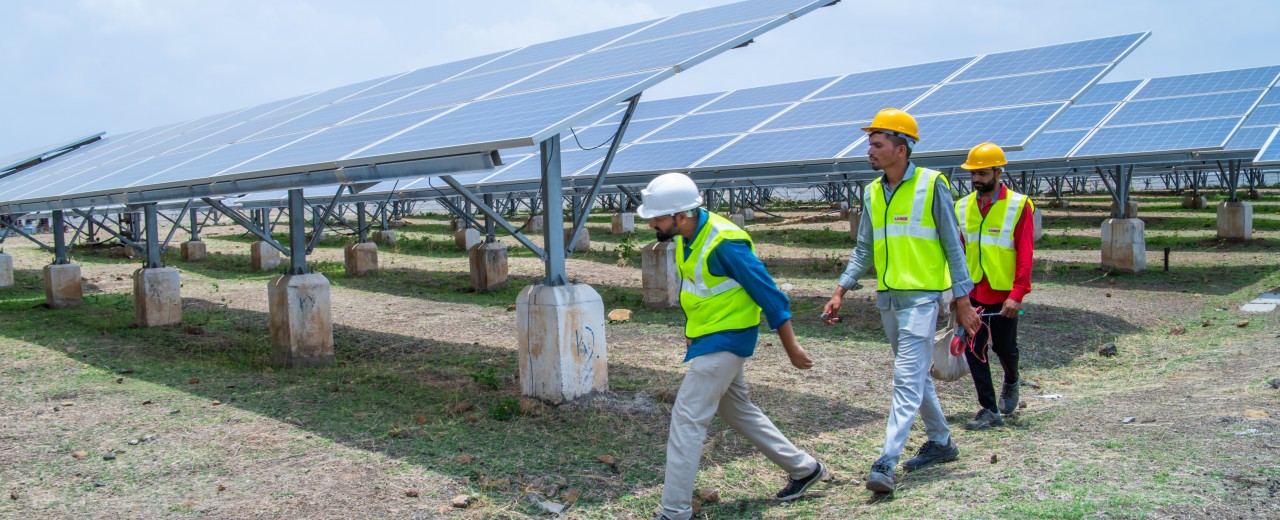 Engineers at the Sakri solar park inspect the solar panels.