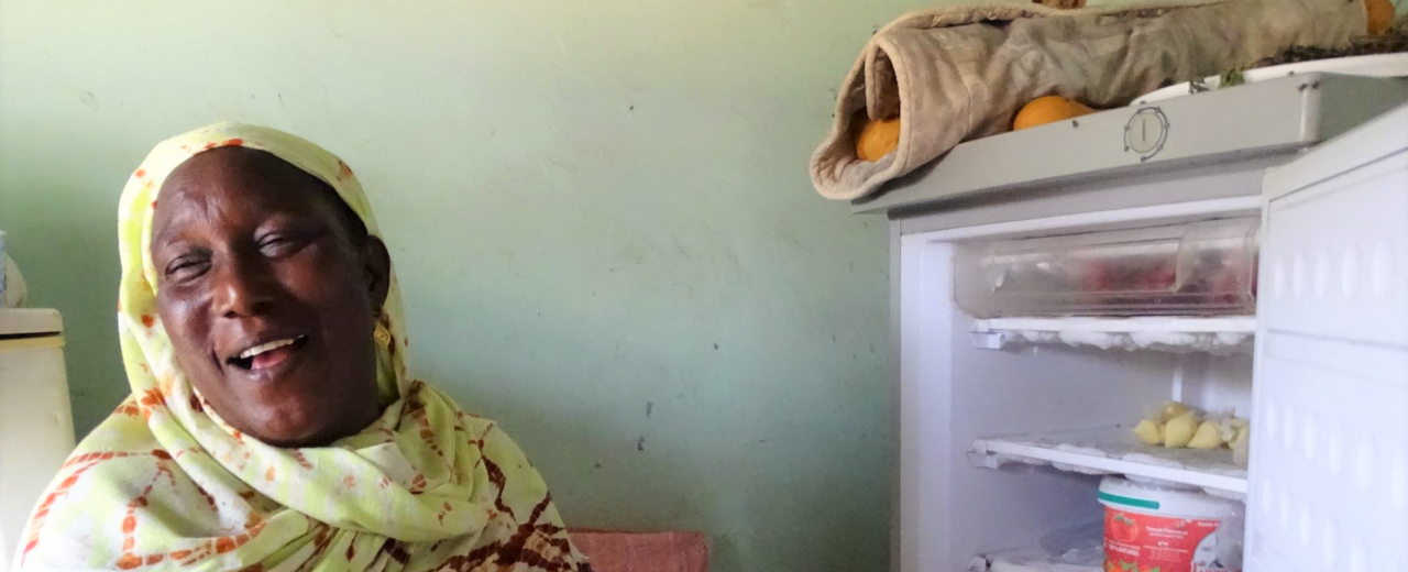  Frau neben geöffnetem Kühlschrank
