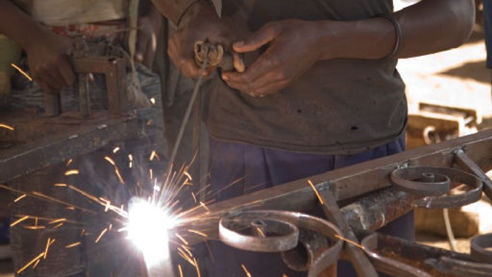 Locksmith carrying out welding work on a metal railing.