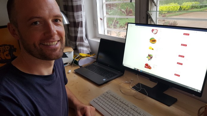 Felix Povel sitzt vor seinem Computer. Auf diesem ist eine Homepage aufgerufen, auf der man Lebensmittel kaufen kann.