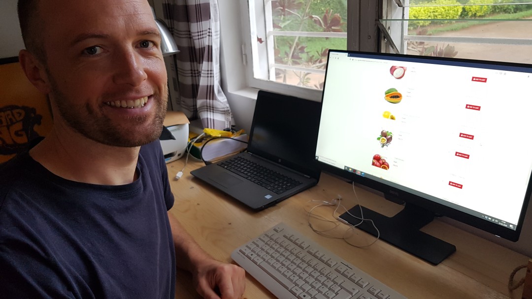 Das Bild zeigt Felix Povel, der vor seinem Computer sitzt. Auf diesem ist eine Homepage aufgerufen, auf der man Lebensmittel kaufen kann.